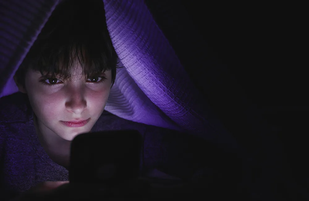 getty-images-V6wkJ91CmU0-unsplash University student sitting on a bench and reading from tablet.