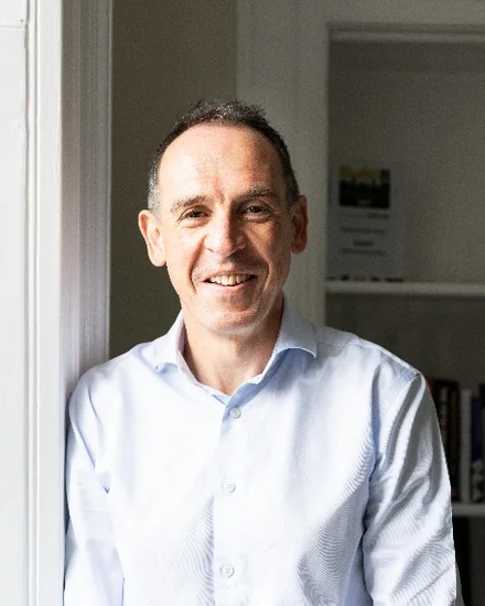Richard Ingle, CEO of Bath Building Society, smiling and leaning against a white door frame